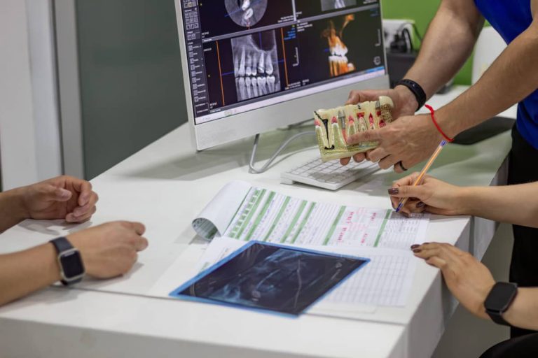 medicul stomatolog explica unui pacient procedura de implant dentar