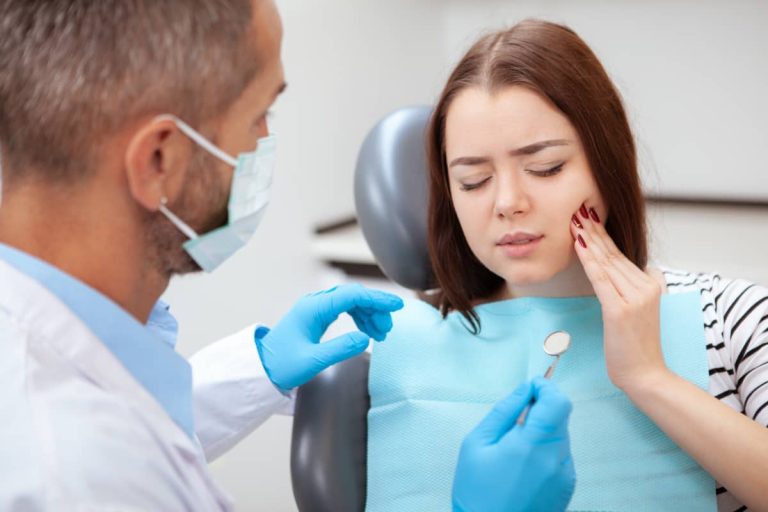 femeie cu durere dentara in cabinetul stomatologic