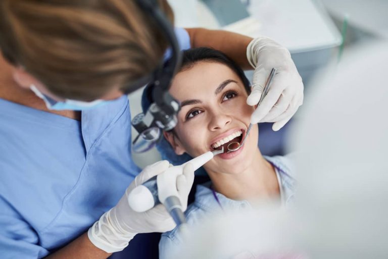 pacienta in cabinetul de stomatologie in timpul procedurii de igienizare dentara profesionala